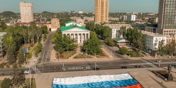 Флаг России, развёрнутый в 5 городах ДНР, уезжает в Москву на церемонию