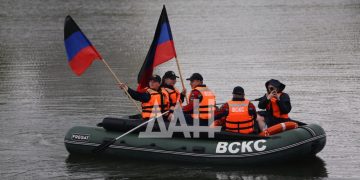 Салют на волнах: в Донецке сотни людей вышли на воду с флагами на сапбордах